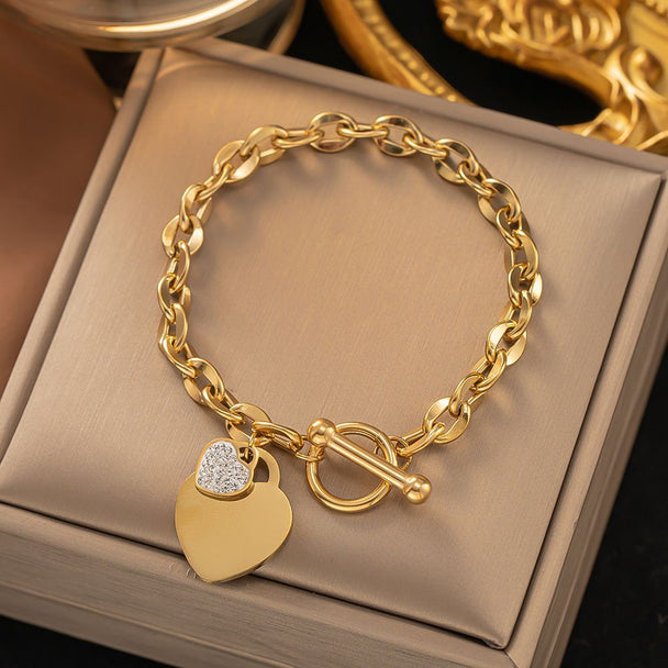 Bold gold curb chain bracelet with double heart charms & pavé CZ. Toggle clasp, adjustable fit. Perfect for everyday style & romantic gifts.