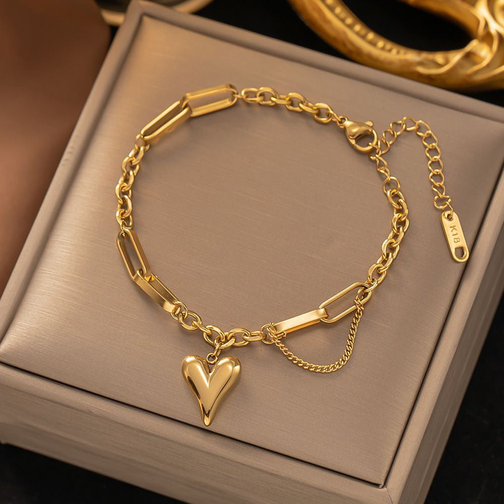 Gold heart charm bracelet with mixed paperclip & curb chain. Adjustable fit, stackable design. Perfect gift for everyday style & romantic elegance.