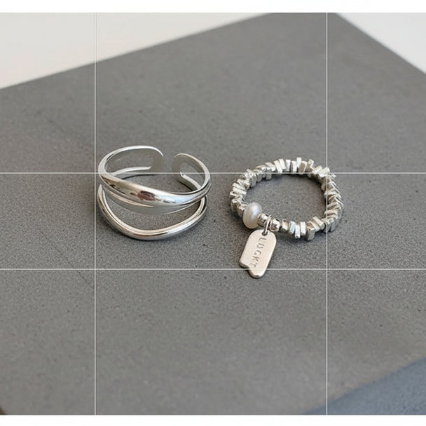Minimalist silver ring set with open triple-band & beaded charm ring. Adjustable fit, stackable design. Perfect for everyday style & casual elegance.