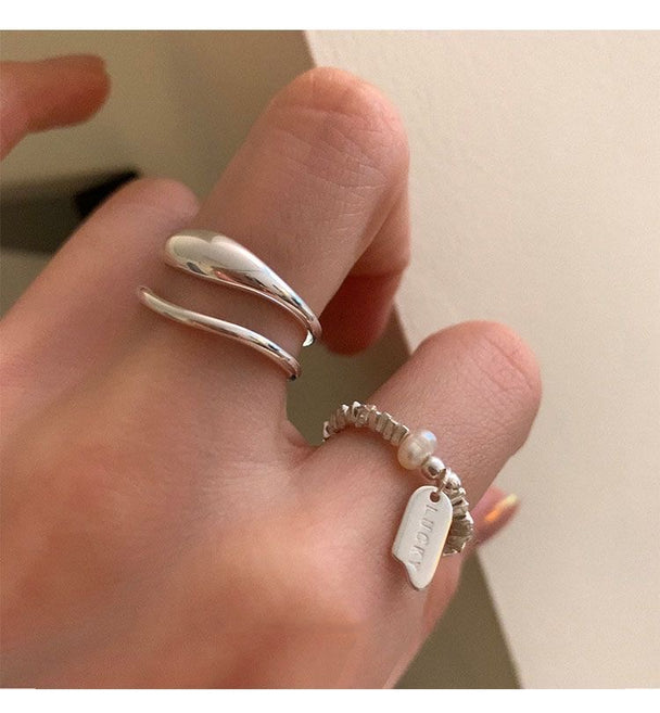 Minimalist silver ring set with open triple-band & beaded charm ring. Adjustable fit, stackable design. Perfect for everyday style & casual elegance.