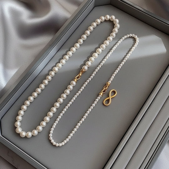 Elegant dual-strand pearl necklace with gold infinity clasp. Wear together or separately. Versatile layered design perfect for everyday elegance & special occasions.