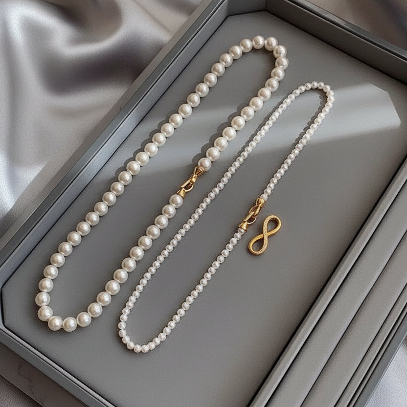 Elegant dual-strand pearl necklace with gold infinity clasp. Wear together or separately. Versatile layered design perfect for everyday elegance & special occasions.