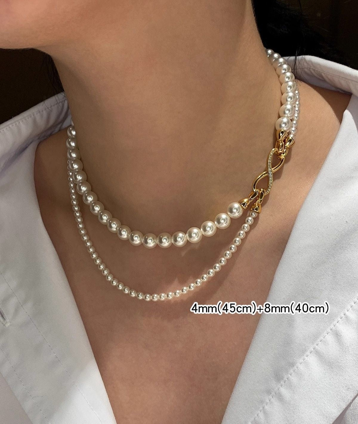 Elegant dual-strand pearl necklace with gold infinity clasp. Wear together or separately. Versatile layered design perfect for everyday elegance & special occasions.