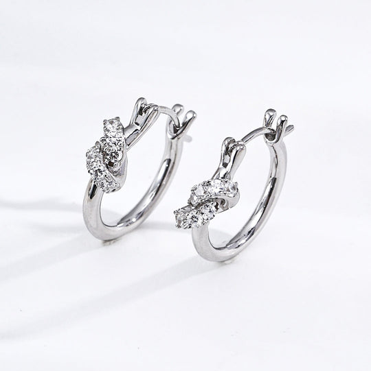 Pair of silver hoop earrings with diamond-like stones on a white background