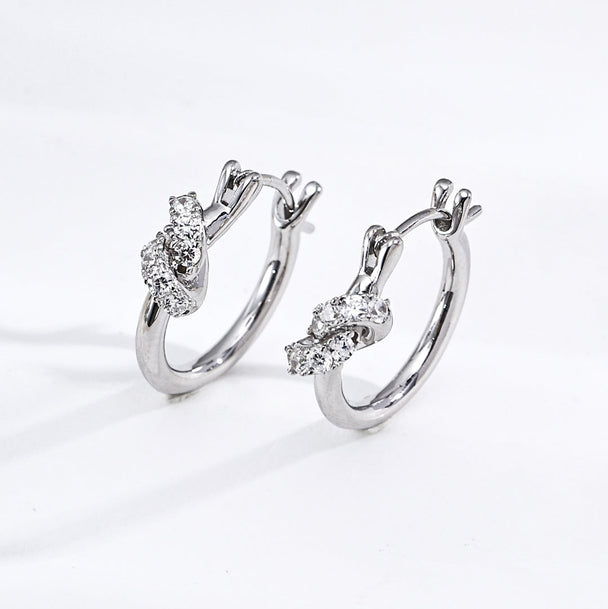 Pair of silver hoop earrings with diamond-like stones on a white background