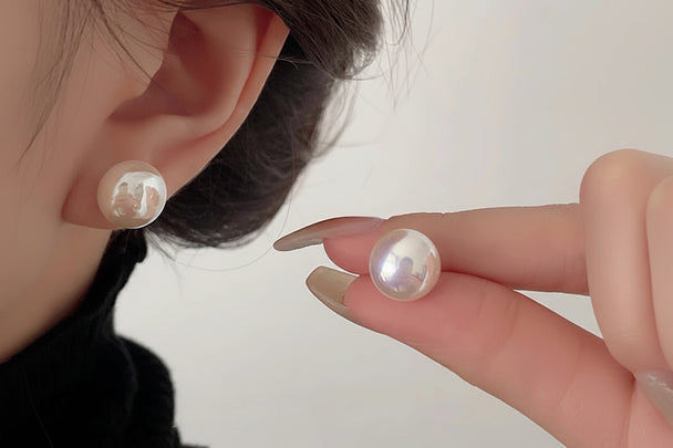 Elegant crystal pearl stud earrings in white or pink. 18K gold-plated, Swarovski pearls, 10-14mm sizes. Perfect for everyday elegance & special occasions.