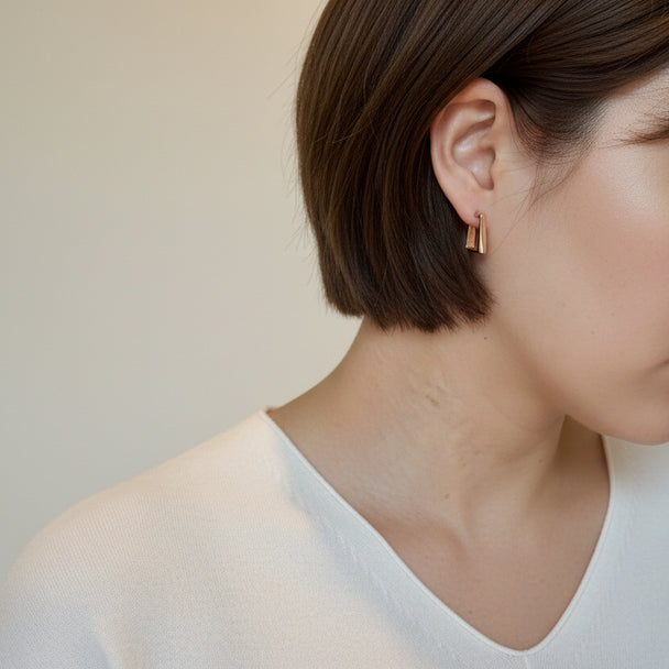 Modern gold bar stud earrings with faceted detail. Lightweight, stackable design. Perfect for everyday elegance & office sophistication.