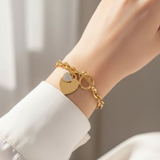 Bold gold curb chain bracelet with double heart charms & pavé CZ. Toggle clasp, adjustable fit. Perfect for everyday style & romantic gifts.