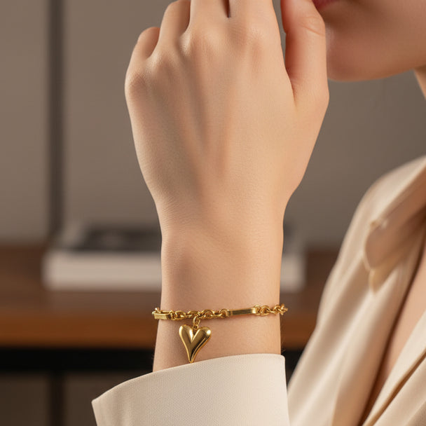 Gold heart charm bracelet with mixed paperclip & curb chain. Adjustable fit, stackable design. Perfect gift for everyday style & romantic elegance.