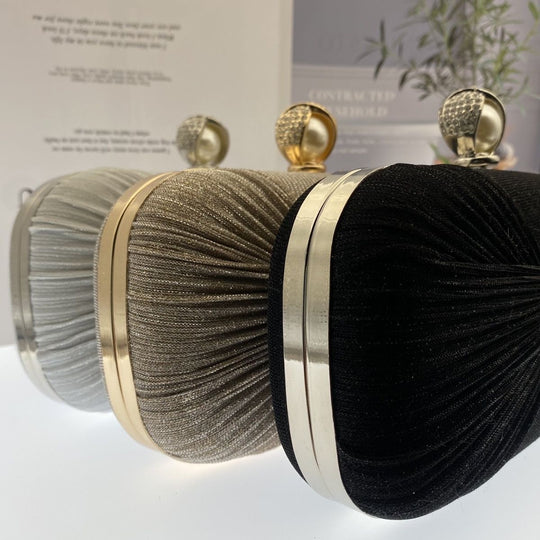 Elegant pleated evening clutch with pearl clasp. Black, silver & gold options. Dual chains for versatile wear. Perfect for weddings, galas, cocktail parties & formal events.