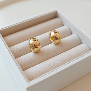 Sleek polished gold oval stud earrings with high-shine finish. Lightweight, minimalist design. Perfect for everyday elegance & effortless style.