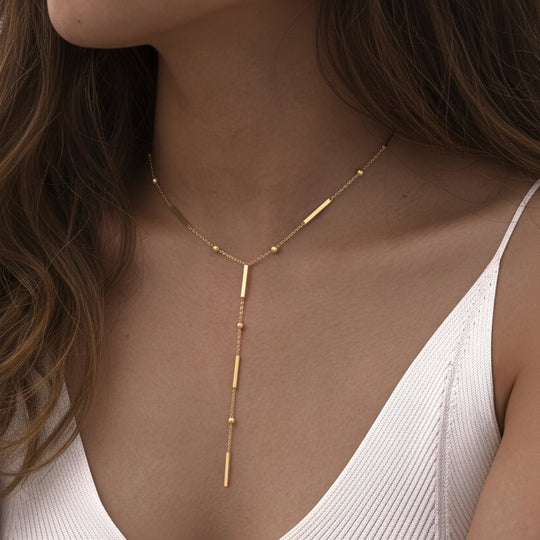 Elegant gold Y-shaped fringe necklace with square beads & pearls. Stainless steel, layered design. Perfect for everyday elegance & modern style.