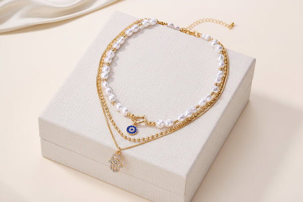 Bold layered pearl necklace with rhinestone pendants. Multi-strand collar design. Perfect for special occasions & statement style.