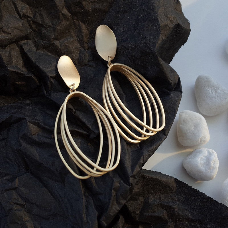 Boho gold teardrop earrings with layered multi-ring design. Lightweight, sculptural style. Perfect for everyday elegance & festival vibes.