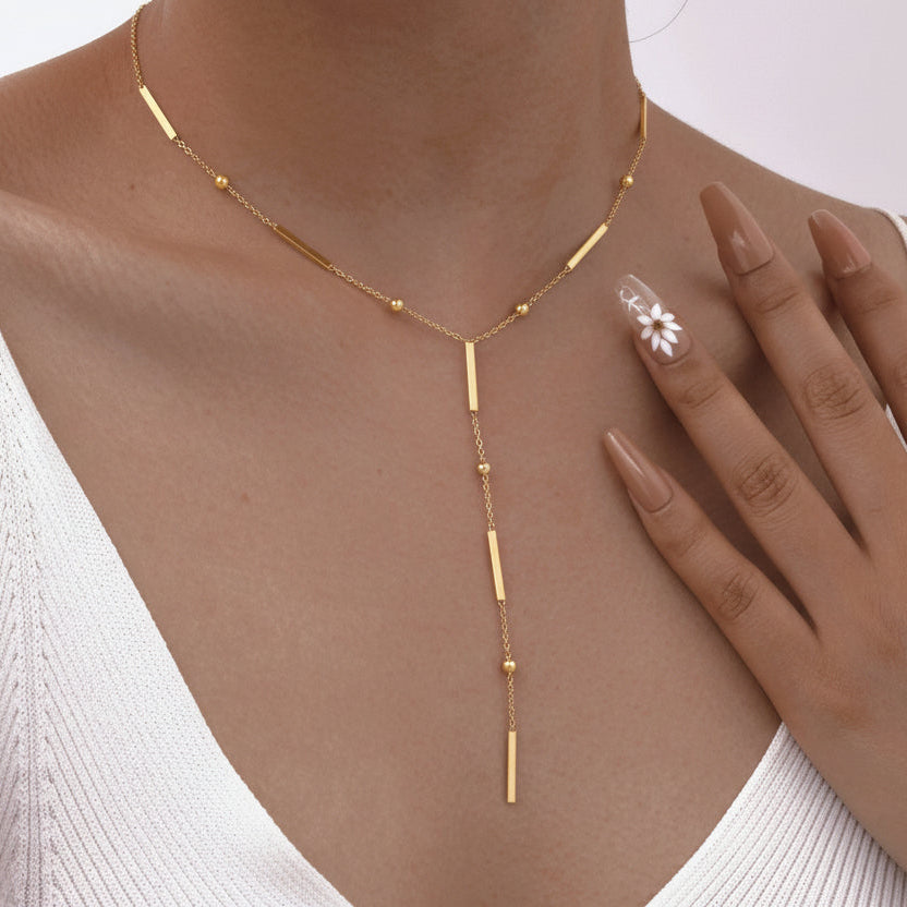 Elegant gold Y-shaped fringe necklace with square beads & pearls. Stainless steel, layered design. Perfect for everyday elegance & modern style.