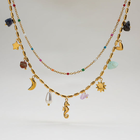 Boho celestial layered gold necklace with moon, star & seahorse charms, gemstones & pearl. 18K gold-plated. Perfect for bohemian style & everyday elegance.