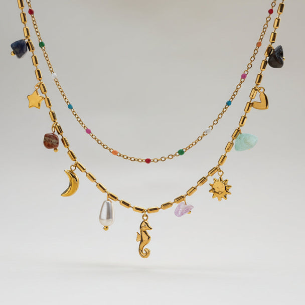 Boho celestial layered gold necklace with moon, star & seahorse charms, gemstones & pearl. 18K gold-plated. Perfect for bohemian style & everyday elegance.