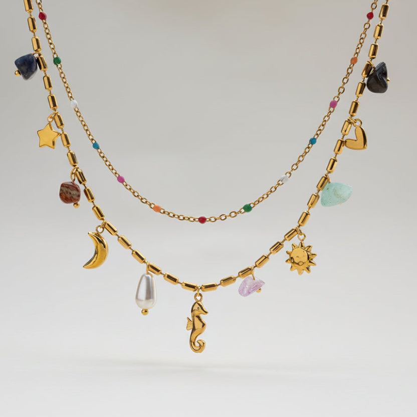 Boho celestial layered gold necklace with moon, star & seahorse charms, gemstones & pearl. 18K gold-plated. Perfect for bohemian style & everyday elegance.