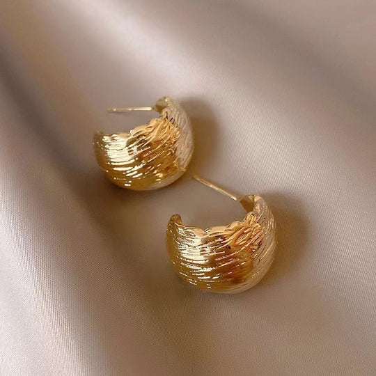 Modern textured wave hoop earrings in gold or silver. Lightweight sculptural design. Perfect for everyday elegance & office style.