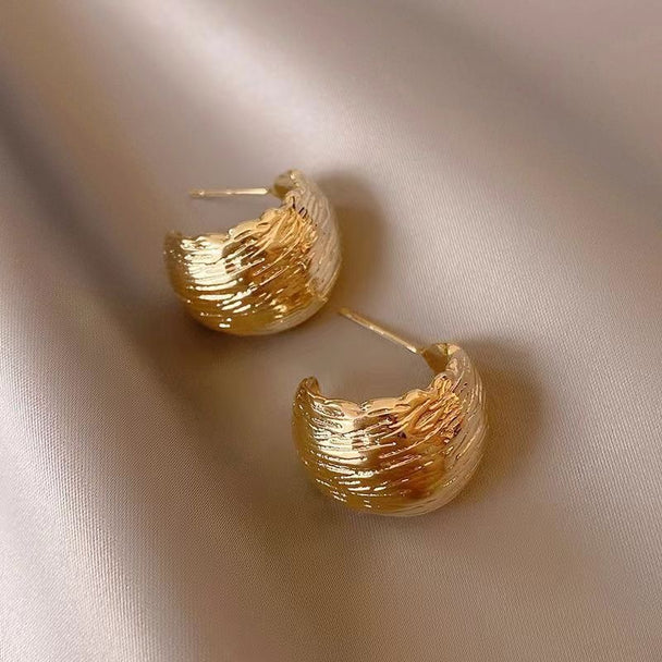 Modern textured wave hoop earrings in gold or silver. Lightweight sculptural design. Perfect for everyday elegance & office style.