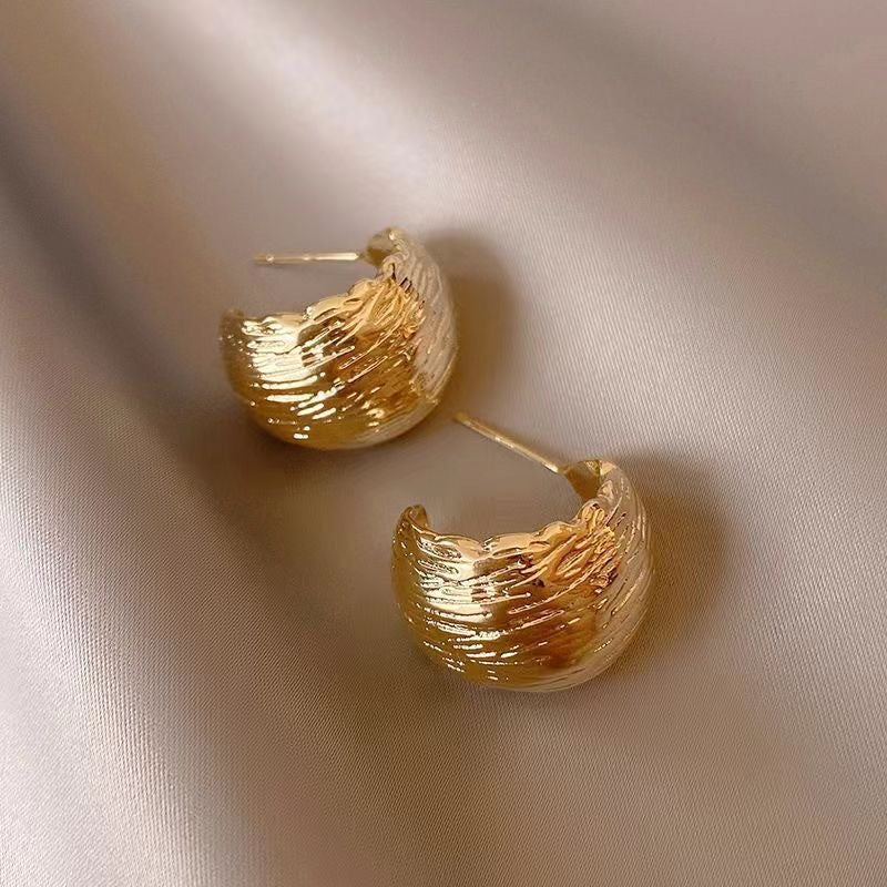 Modern textured wave hoop earrings in gold or silver. Lightweight sculptural design. Perfect for everyday elegance & office style.
