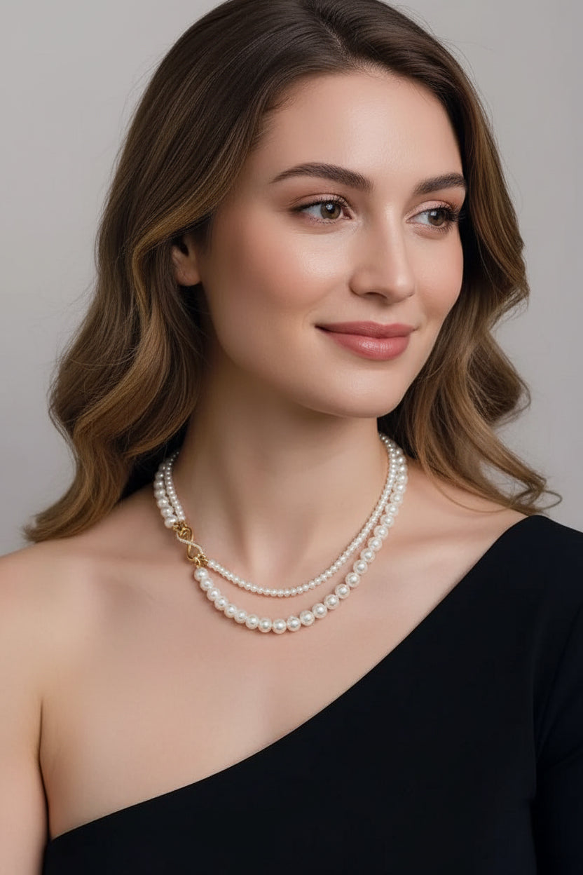 Elegant dual-strand pearl necklace with gold infinity clasp. Wear together or separately. Versatile layered design perfect for everyday elegance & special occasions.